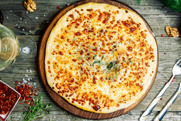  Azerbaijani restaurant dish with vegetable decor on a wooden background. Khachapuri in Megrelian on the Board.