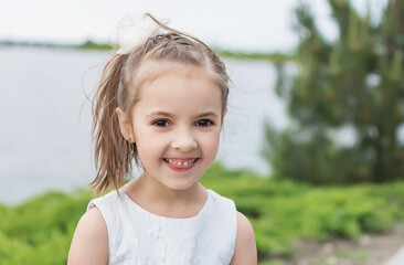 happy little girl on the beach. little girl in a white dress. little girl lying on the grass. little girl walking on the road