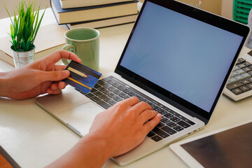 Hands holding credit card and using laptop. Online shopping