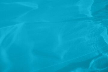 Trendy mint blue colored low contrast abstract background with light and shadows caustic effect. Light passes through a glass. Water background. 2021 year color trend