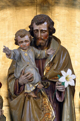 Saint Joseph holds the baby Jesus, a statue on the high altar in the parish church of Saint Joseph...
