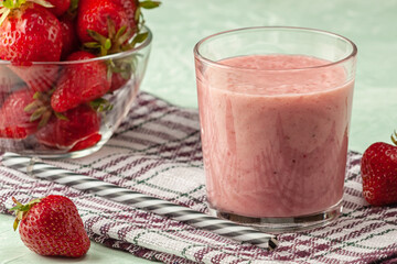 Strawberry smoothie with milk in a glass on a green background, healthy eating for breakfast and...
