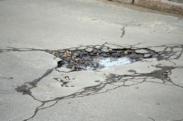 Poor condition of the road surface. Spring season. Hole in the asphalt, risk of movement by car, bad asphalt, dangerous road, potholes in asphalt.  Kiev,Ukraine