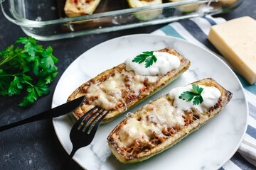 Homemade zucchini stuffed with meat, mushrooms and cheese. Squash boats. Loaded zucchini. Diet menu. Side view, top view.