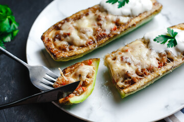 Homemade zucchini stuffed with meat, mushrooms and cheese. Squash boats. Loaded zucchini. Diet menu. Side view, top view.