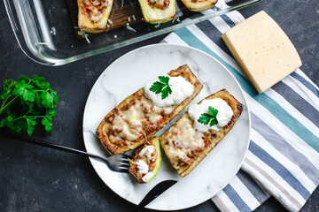 Homemade zucchini stuffed with meat, mushrooms and cheese. Squash boats. Loaded zucchini. Diet menu. Side view, top view.