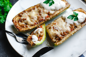 Homemade zucchini stuffed with meat, mushrooms and cheese. Squash boats. Loaded zucchini. Diet menu. Side view, top view.
