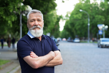 Handsome elderly man with a beard in the city. Summer business man portrait