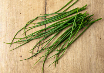 Green onions on a wooden table.