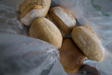 Five loaves inside a transparent plastic bag.