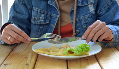 woman eating salad and pancake