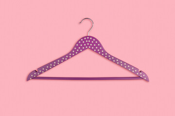 Obraz na płótnie Canvas Violet wooden clothes hanger on a pink background copy space.
