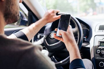 Businessman ignoring safety and texting onmobile phone while driving