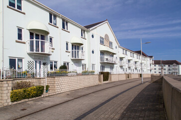 Fototapeta na wymiar Row of modern beach front apartments with balconies giving views over the bay - UK