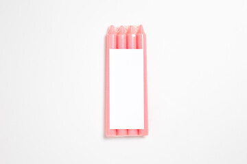 Pack of pink candles Mock-up with a blank label on a white background. High-resolution photo.