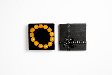 Amber material prayer beads (rosary) in a gift box on white background.High-resolution photo.