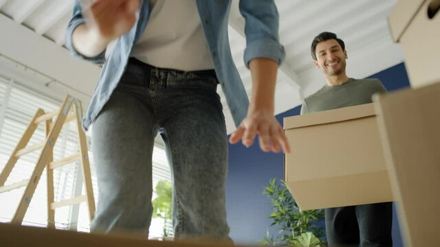 Video of couple going with cardboard boxes while moving house. Shot with RED helium camera in 8K