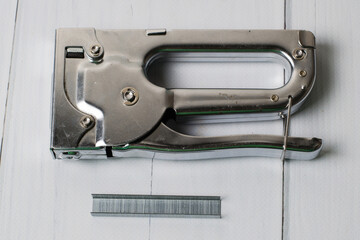 Concept of repair and construction. Construction brackets, stapler on a dark gray wooden...