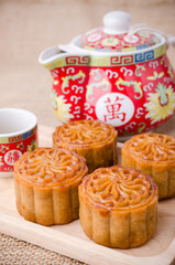 Chinese mid autumn festival foods. Traditional mooncakes on table setting with teapot.