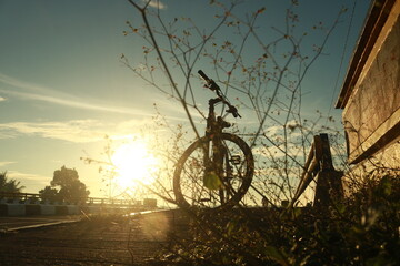 bike on the road and the sun rises at background