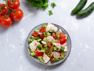 Vegan fattoush salad in a gray plate with ingredients on a gray background. Top view. Levantine salad, which is prepared from dried pita or pita with the addition of various vegetables and herbs. 