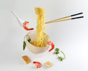 Yellow seafood prawn coriander leaf noodle soup elevated flying suspended in air with soup spoon...