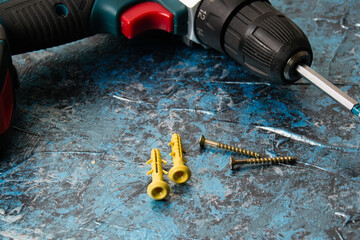 Screwdriver and dowels on concrete. Concept advertising construction companies