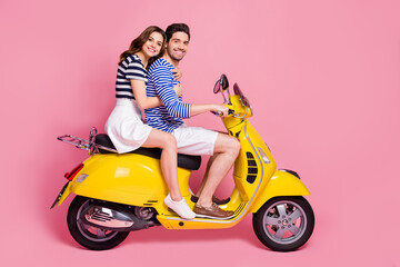 Fototapeta na wymiar Profile side view portrait of his he her she nice attractive cheerful cheery couple riding moped traveling having fun time isolated on pink pastel color background