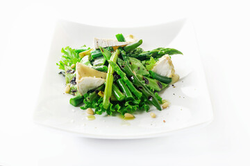 Warm salad made of green peas pods, string beans, asparagus, lettuce leaves, brie cheese, cedar nuts and olive oil.
