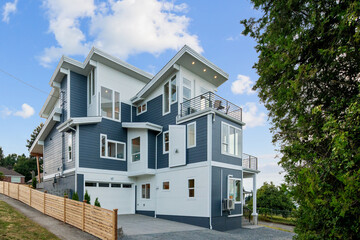 View of a white and blue home with nice outdoor landscape