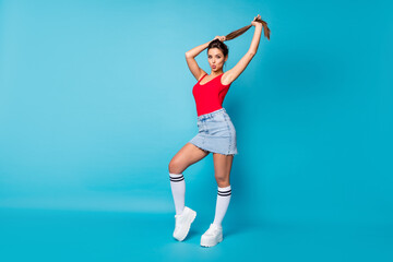 Full size photo of stunning chic girl send air kiss prepare for 14-february date hold hand make ponytail hairstyle wear red legs tank-top white singlet isolated over blue color background