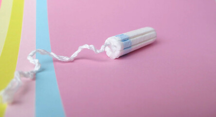 White cotton tampon on pink background. Menstruation. Feminine Hygiene in periods, protection concept, flat lay.