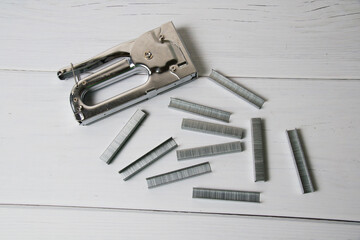 Concept of repair and construction. Construction stapler with brackets on a gray background top view