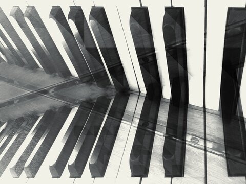 Black and white image of a piano keyboard with abstract surreal mirroring effects