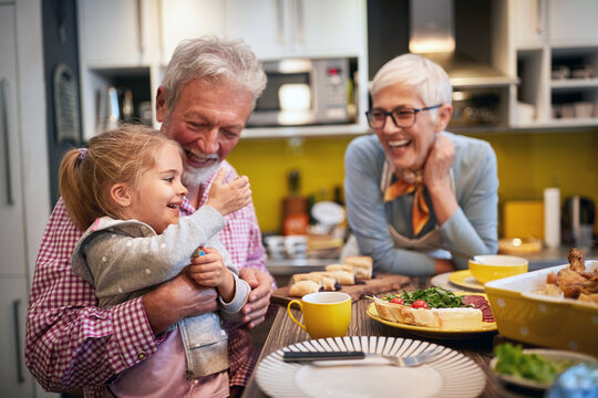 Happy child with gradparents in kitchen