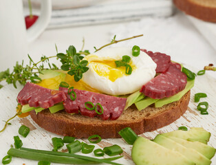 toast with poached egg and avocado on a round board, morning breakfast