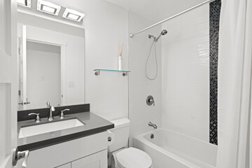 Stylish bathroom interior with dark grey countertop fitted with white porcelain sink.