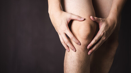 Man use hands hold on his knee.