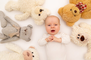 portrait of a child on a white background with plush bear toys. Baby 6 months among toys. Space for text