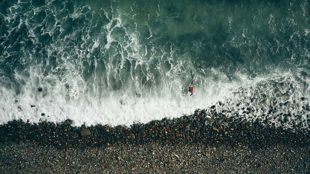 surfer in red coming back to shore