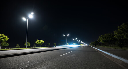 asphalt road and street lights at night © Daniel