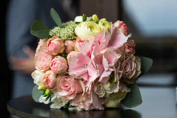 The bride's wedding bouquet lies on the table.