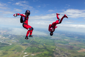 Two sports parachutist build a figure in free fall. Extreme sport concept.