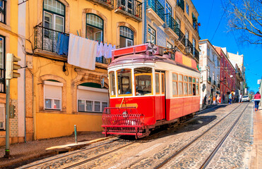 Naklejka na ściany i meble Vintage red tram on the old streets of Lisbon, Portugal. Portugal tram. Famous landmarks of Lisbon.