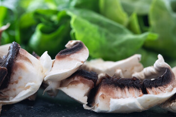 Fresh sliced mushrooms Chopped mushrooms closeup. champignons and spinach. healthy food background.
