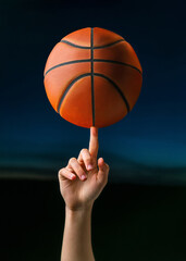 Close up of professional basketball player spinning a ball on hand finger. Street basketball athlete training for competition