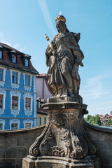 Obraz premium Blaues Haus und Statue der Königin Kunikunde an der unteren Rathausbrücke in Bamberg