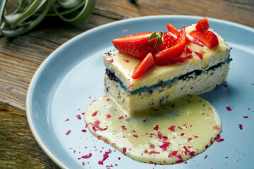 Healthy dessert - cottage cheese casserole with poppy seeds and strawberries in a plate on a wooden background