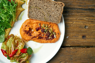 Healthy breakfast - omelet with kimchi and baked peppers hummus in a plate on a wooden background