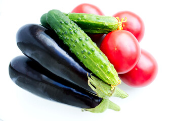 new crop: fresh eggplant, green cucumbers, red tomatoes on a light background, isolated. Healthy vegetables, comfortable digestion. Proper nutrition, weight loss. Seasonal vegetables